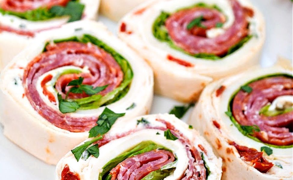 A plate of pinwheels filled with salami, pepperoni and sundried tomato.