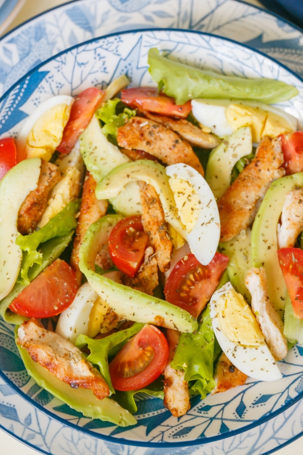 chicken salad with avocados in a blue and white bowl