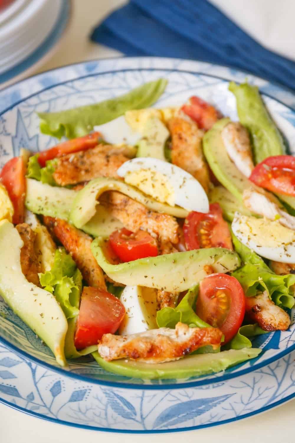 chicken salad with avocados in a blue and white bowl